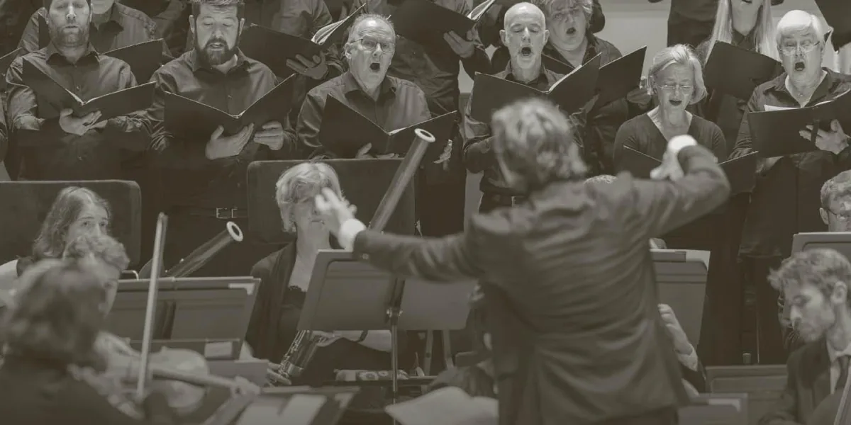 Maxim Emelyanychev conducts the orchestra with the chorus singing behind